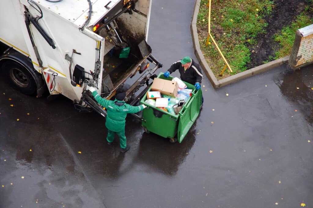 Aerial shot of a refuse collection lorry and two operatives emptying a commercial bin